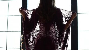 Güzel bir genç kız onun pelerini alır. Kadın undresses ve aynı donla kalır