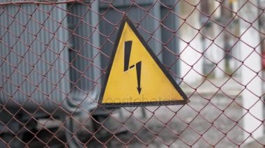 Elektrik tehlikesi uyarı işareti. Enerji santrali çitin üzerine işaret