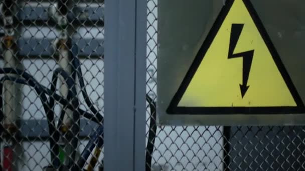 電気の危険性に関する警告のサインです。発電所のフェンスの上に署名します。 — ストック動画