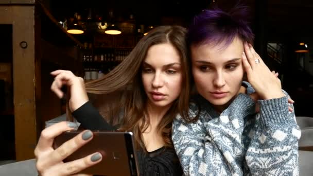 두 여자는 식당에서 selfies를 만들고 있다. 여자는 테이블에서 카페에서 사진 — 비디오