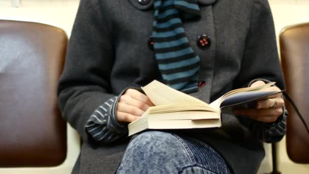 Ein Mädchen liest in einem U-Bahn-Wagen ein Buch — Stockvideo