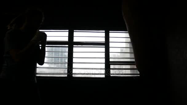 Un atleta sta pugilando una borsa. Luce drammatica dalla finestra — Video Stock