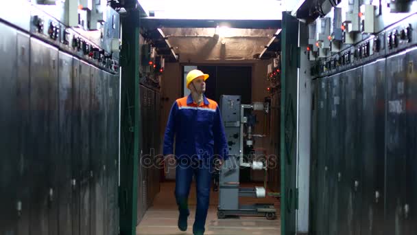 Un travailleur en uniforme et casque effectue un contournement de l'équipement à la station — Video