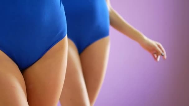 Twee meisjes dansen moderne dansen. Vrouwen in zwemkleding en beenwarmers — Stockvideo