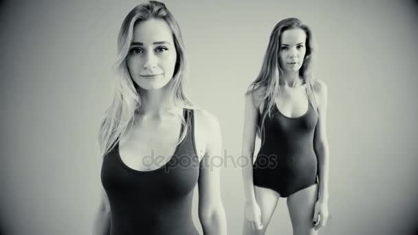 Due ragazze ballano balli moderni. Donne in costume da bagno e scaldamuscoli — Video Stock