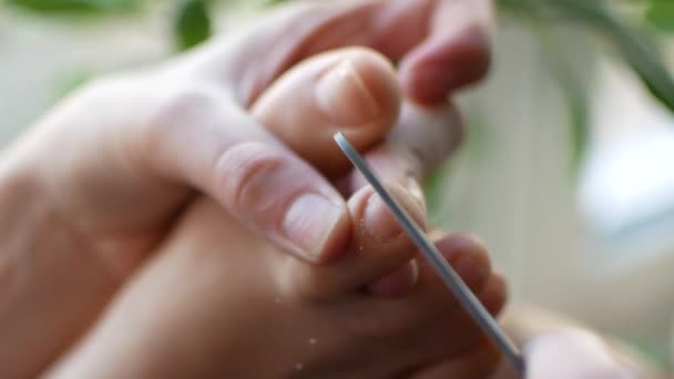 Het meisje doet een pedicure thuis. Een vrouw is haar nagels peeling op haar voeten, close-up — Stockvideo