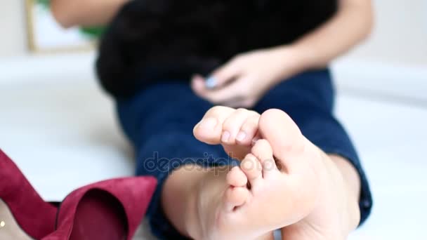 A young beautiful girl is resting in her apartment. A black cat is sitting in the arms of a woman — Stock Video