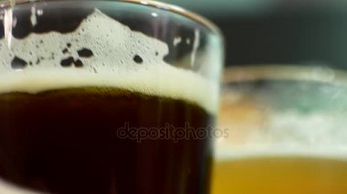 Bir bardak bira karanlık ve ışık yakın çekim. IPA ve lagger bira gözlük. Arkadaş barda bira içiyorsun