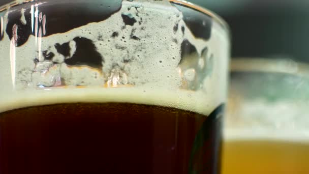 A glass of dark and light beer close-up. IPA and lagger in beer glasses. Friends are drinking beer in the bar — Stock Video