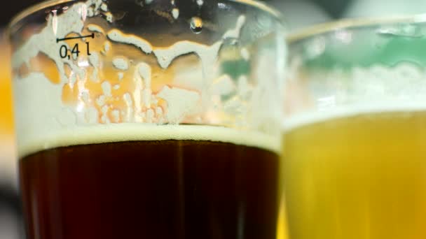 Ένα ποτήρι μπύρα σκοτάδι και το φως γκρο πλαν. ΕΙΠΑ και μπω σε ποτήρια μπίρας. Φίλοι πίνουν μπίρα στο μπαρ — Αρχείο Βίντεο