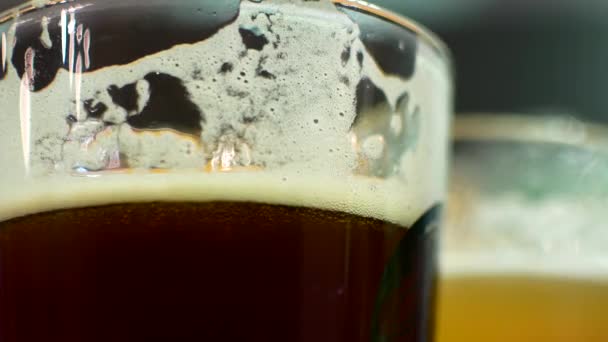 Egy pohár sötét és világos sör közelről. IPA és a lusta ember a pohár sör. Meg a sört ivott a bárban — Stock videók