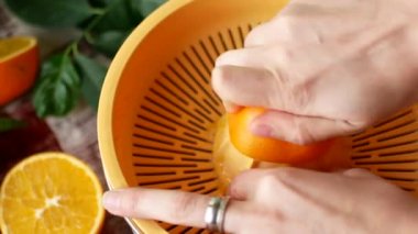 Kız portakal ile bir el juicer gelen suyu sıkar