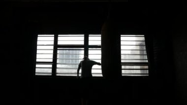 Erkek atlet çok kızmış. Boksör armut vurur ve umutsuzca pencereye yürür