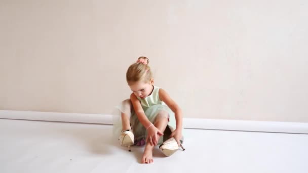 A child dresses shoes sitting on the floor — Stock Video