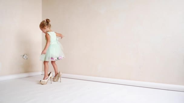 Жіноче взуття на дитину. Дитячі ноги носять жіноче взуття — стокове відео