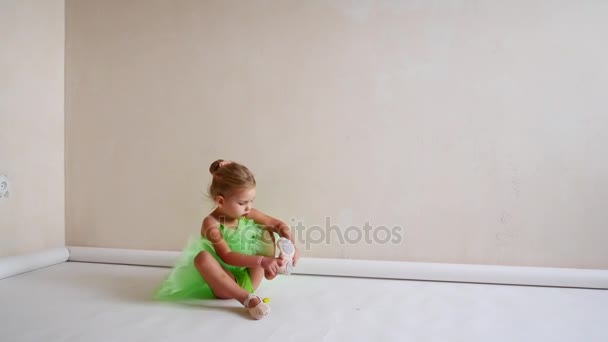 A child dresses shoes sitting on the floor — Stock Video