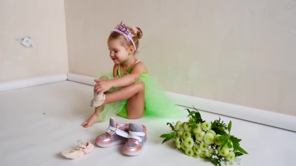 A child dresses shoes sitting on the floor — Stock Video