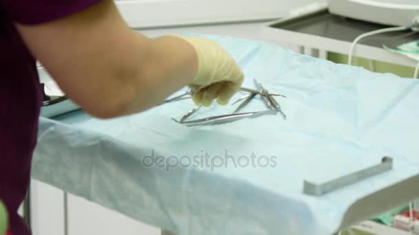 Consultorio dental. Preparándose para la cirugía, las herramientas se colocan en una mesa estéril — Vídeos de Stock