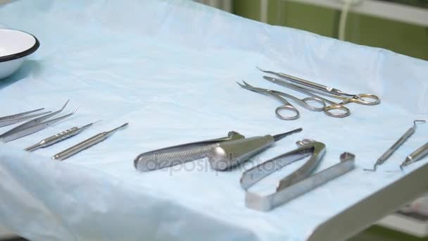 Стоматологический кабинет. Готовясь к операции, инструменты выкладываются на стерильный стол — стоковое видео