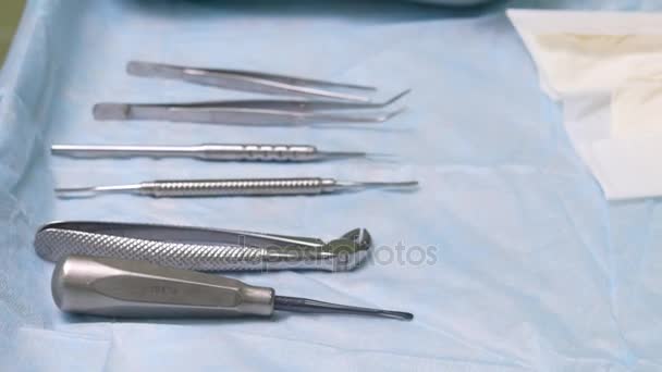 Consultorio dental. Preparándose para la cirugía, las herramientas se colocan en una mesa estéril — Vídeo de stock