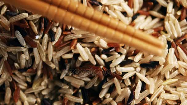 Il riso viene raccolto con bastoncini di bambù. Video cinematografico su riso crudo messo bacchette — Video Stock