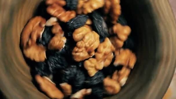 Een plaat met noten en rozijnen cirkelen in een cirkel. Gezonde voeding — Stockvideo