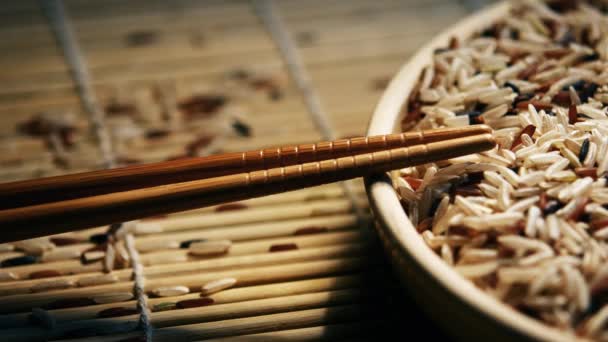 En tallrik med en mängd rå ris och bambu pinnar — Stockvideo
