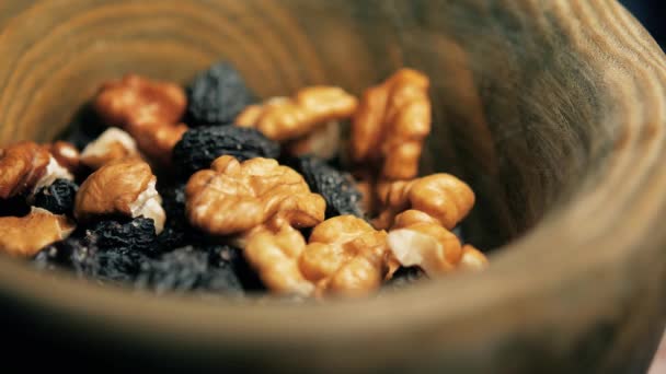Deska s ořechy a rozinkami. Dýňová semínka se nalije do misky — Stock video