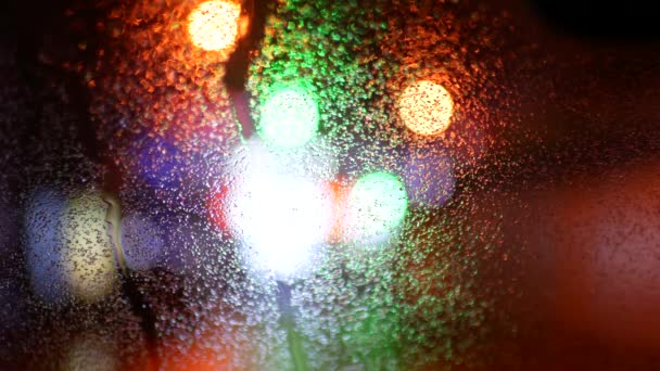 Multicolored lights in blur. Wet automotive glass — Stock Video