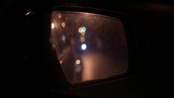 Espejo retrovisor húmedo del coche. Tráfico urbano nocturno — Vídeos de Stock