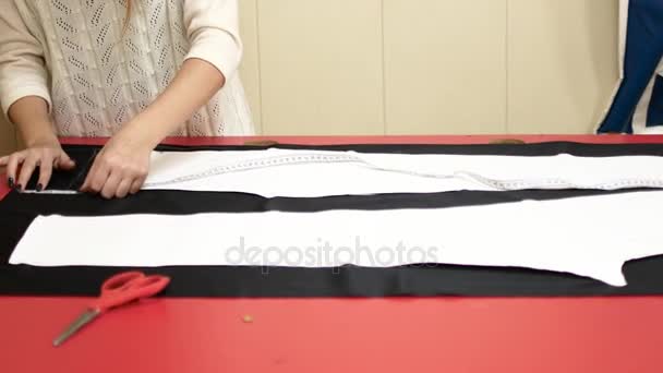 Designer de roupas está trabalhando com medições em uma mesa de estúdio — Vídeo de Stock
