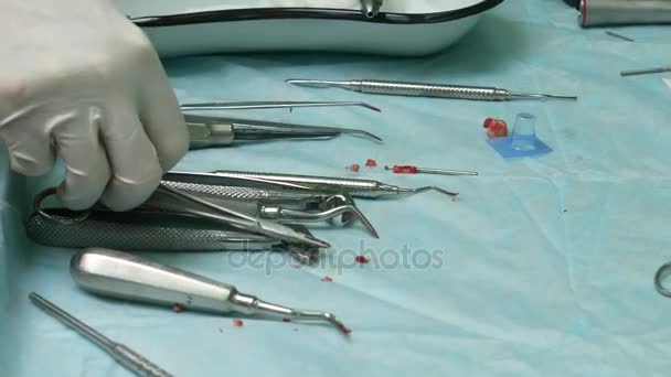 Instrumentos dentários para remover o dente na mesa. Dente rasgado ensanguentado — Vídeo de Stock