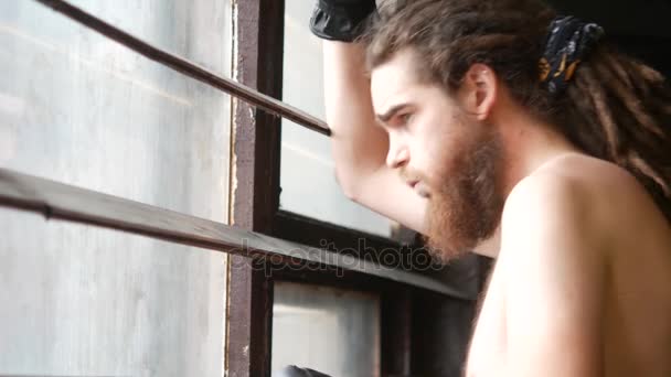 Un atleta masculino llega a la ventana con persianas. El tipo mira por la ventana y no asiente con la cabeza. — Vídeo de stock