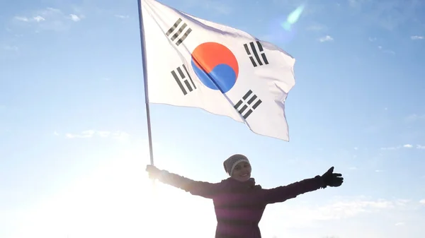 Девушка-чирлидер с флагом Южной Кореи радуется и поддерживает спортсменов — стоковое фото