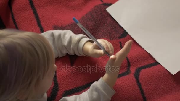Dziewczyna jest rysunek, leżącego na czerwonym dywanie. — Wideo stockowe