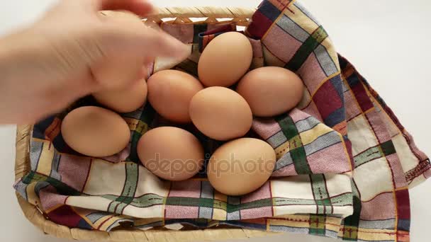 Huevos en una cesta rústica, una mano femenina toma unos pocos . — Vídeo de stock