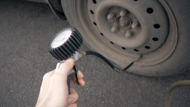 Hand en auto wiel toe te voegen luchtdruk — Stockvideo