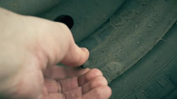 Чоловік встановлює сосок у автомобільне колесо — стокове відео