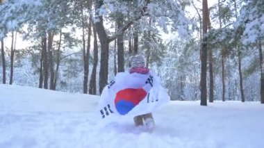 Güney Kore bayrağı olan küçük kız. kış orman.