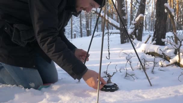 El hombre enciende un quemador en el bosque de invierno. El concepto de turismo . — Vídeo de stock