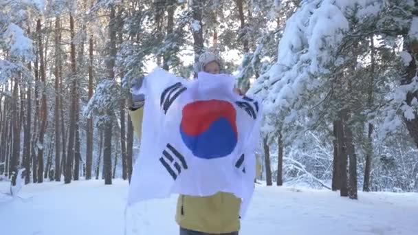 Uma menina com uma bandeira sul-coreana senta-se nos ombros de seus pais . — Vídeo de Stock