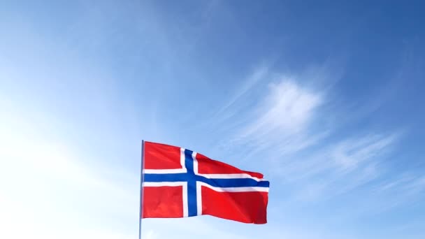 Vermelho com cruz azul Bandeira nacional norueguesa está lentamente acenando no céu azul claro no mastro branco . — Vídeo de Stock