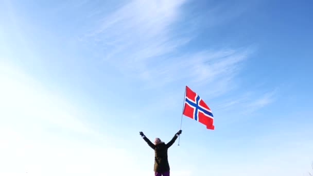 Frau mit der norwegischen Flagge gegen den blauen Himmel. Fan-Unterstützung. — Stockvideo