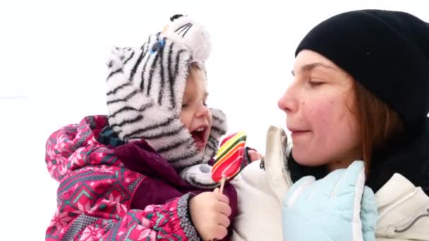 Mutter und Tochter essen Süßigkeiten. Wintervideo. — Stockvideo