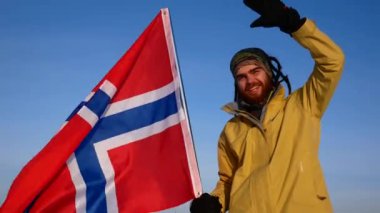 Mavi gökyüzü karşı bir Norveçli bir close-up Norveç bayrağı ile. Milli takım için destek.