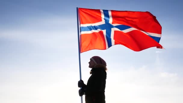Жінка з прапором Норвегії проти синього неба. Підтримки вентилятор. — стокове відео