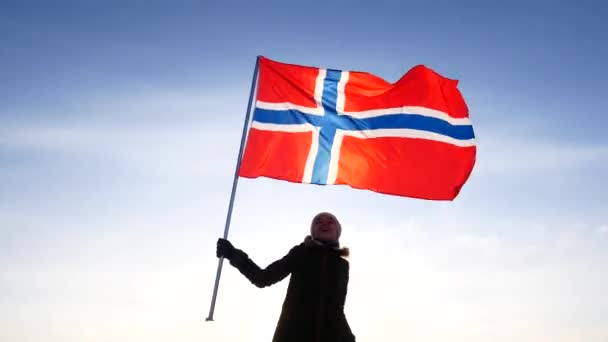 Mulher com a bandeira da Noruega contra o céu azul. Apoio do ventilador . — Vídeo de Stock