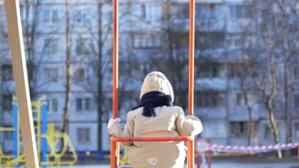 Jeune fille se balançant sur la place des enfants. Vidéo de l'arrière — Video