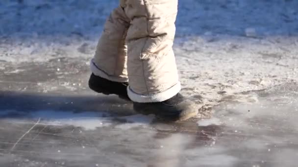 Un niño camina sobre hielo sin patines . — Vídeo de stock