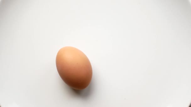 Rotação de ovos em um fundo branco. conceito de tempo, correndo no local . — Vídeo de Stock